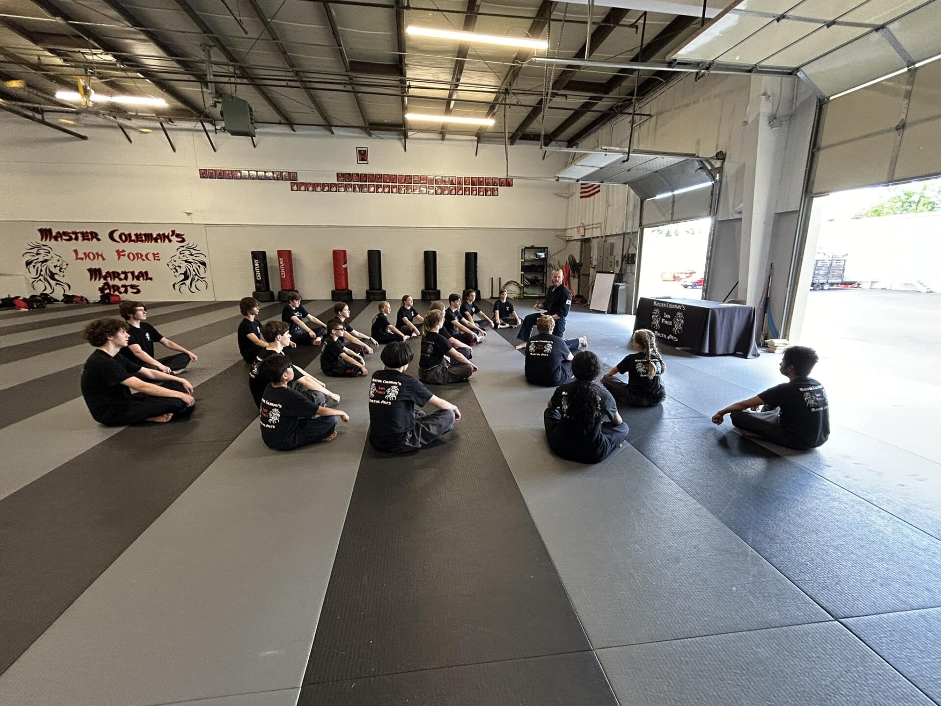 a group of people gathered in a gym, possibly participating in a martial arts class or a workout session